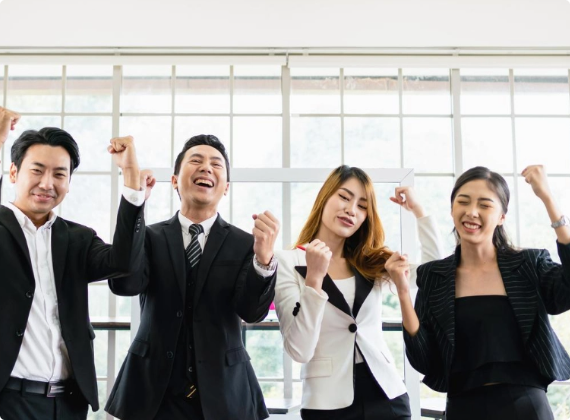 Group of four jubilant business professionals