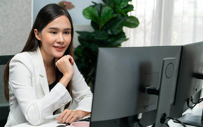 SME buyer evaluating ERP software on dual office monitors.